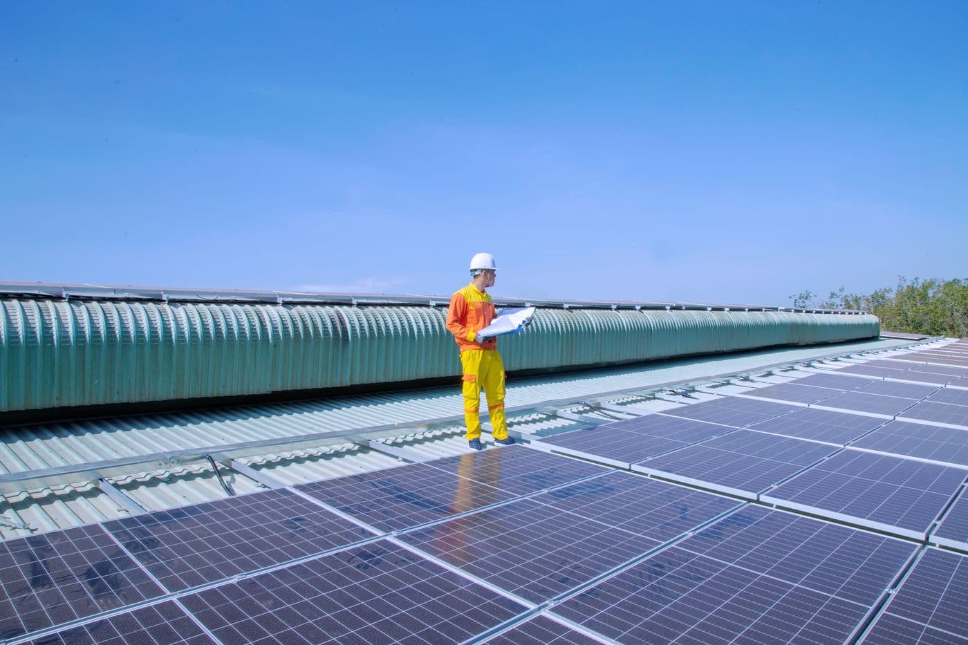 Technicien en tenue de chantier sur une toiture photovoltaïque